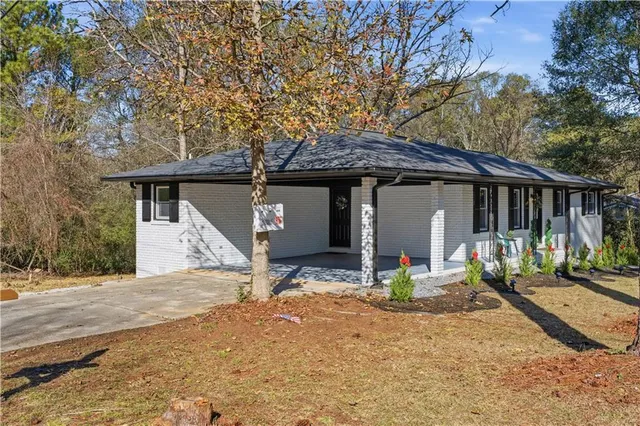 a view of house with backyard and sitting area