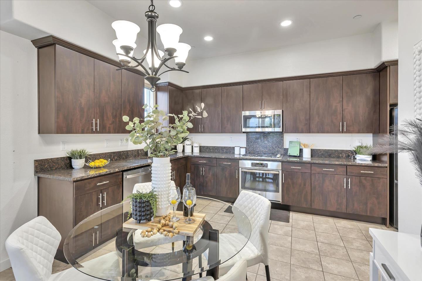 5814 Riley Way Newark, CA 94560 - Photo 11 of 46 a kitchen with stainless steel appliances granite countertop a dining table chairs and granite counter tops