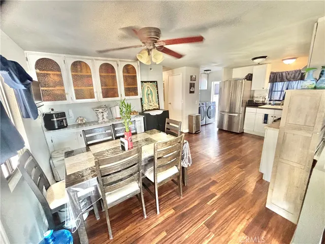 a living room with stainless steel appliances furniture a rug and a large window