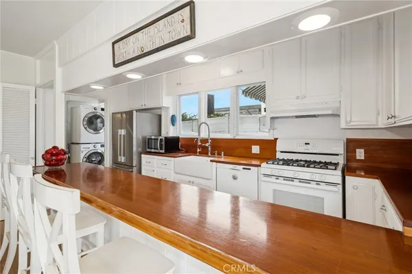 a kitchen with stainless steel appliances granite countertop a stove and white cabinets with wooden floor