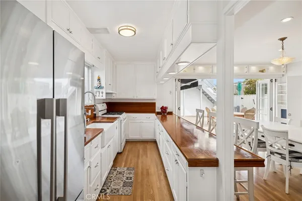a view of a kitchen with kitchen island wooden floor and stainless steel appliances