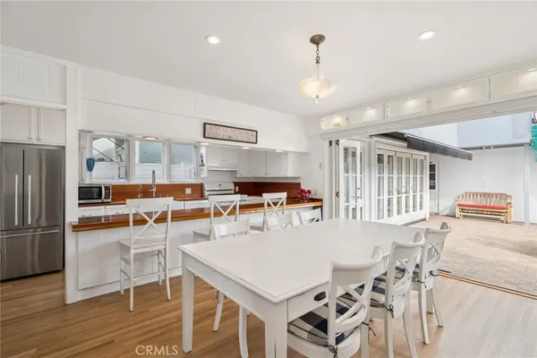 a view of a dining room with furniture a kitchen and chandelier