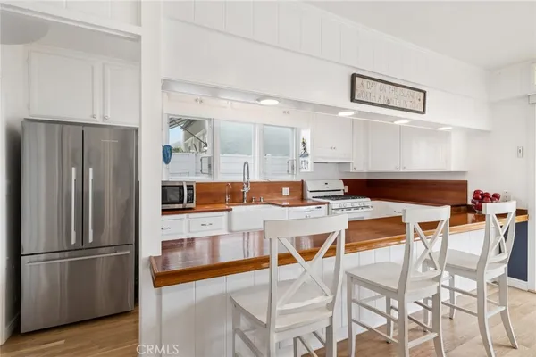 a kitchen with stainless steel appliances kitchen island granite countertop a refrigerator and a stove top oven