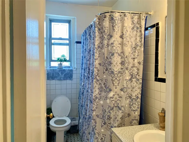 a bathroom with a toilet and a shower curtain
