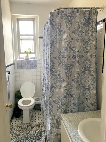 a bathroom with a granite countertop toilet a sink and a shower