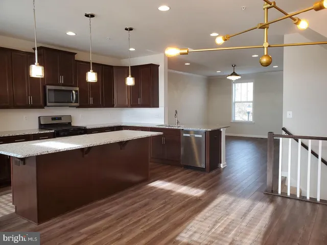 a large kitchen with lots of counter space a sink appliances and cabinets