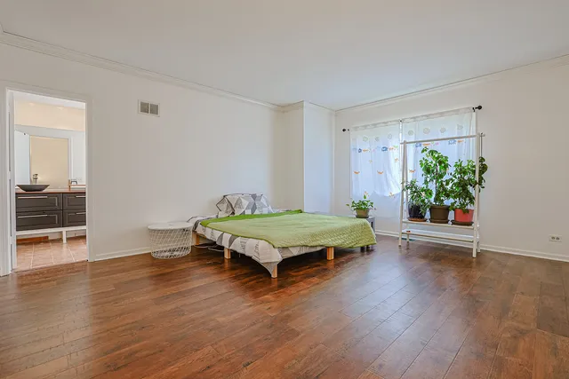 a bedroom with wooden floor and a bed