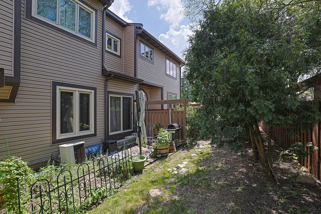 a view of brick house with a yard and plants