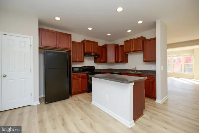 a kitchen with stainless steel appliances granite countertop a refrigerator a sink and a stove