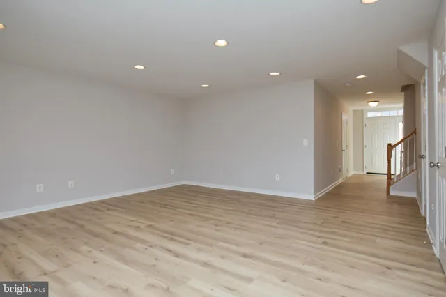 a view of an empty room with wooden floor and a glass door