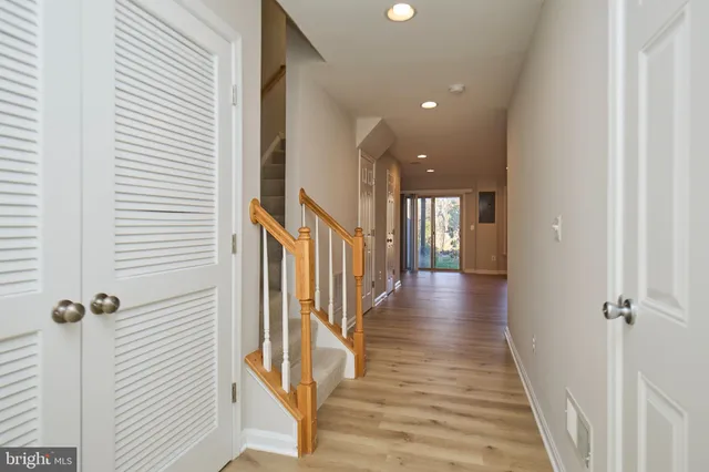 a view of a hallway with wooden floor and staircase