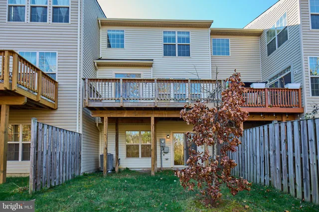 a view of a house with brick walls and a yard with wooden fence