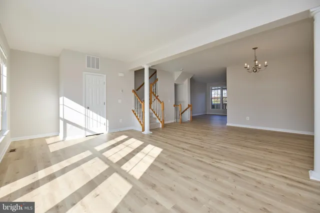 a view of a livingroom with wooden floor and stairs