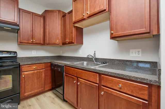 a kitchen with granite countertop stainless steel appliances sink and cabinets