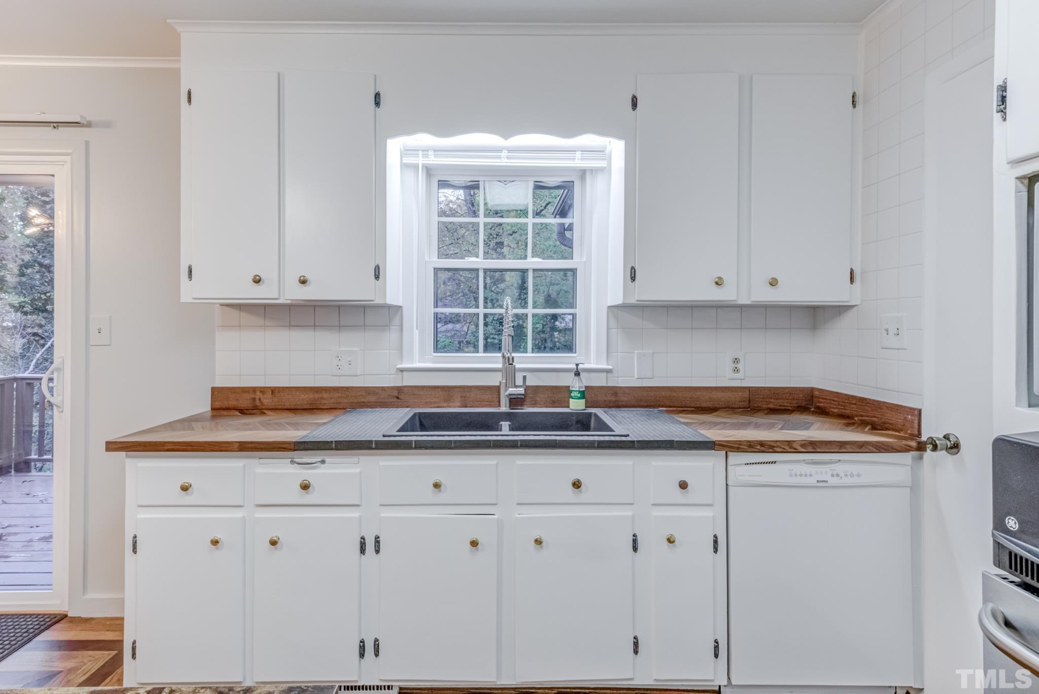 3213 Julian Drive Raleigh, NC 27604 - Photo 24 of 54 a kitchen with granite countertop white cabinets and a window