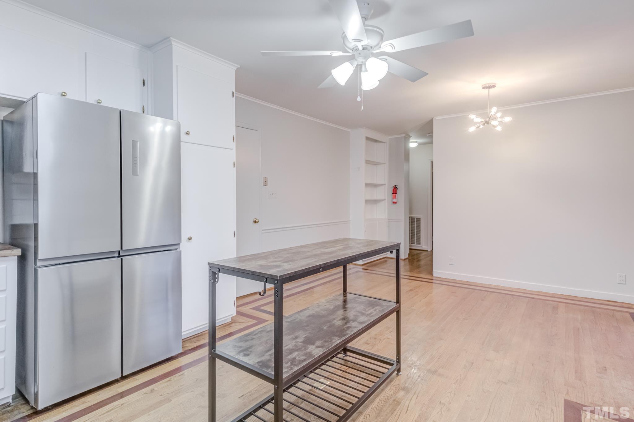 3213 Julian Drive Raleigh, NC 27604 - Photo 26 of 54 a kitchen with kitchen island a counter top space wooden floor and ceiling fan
