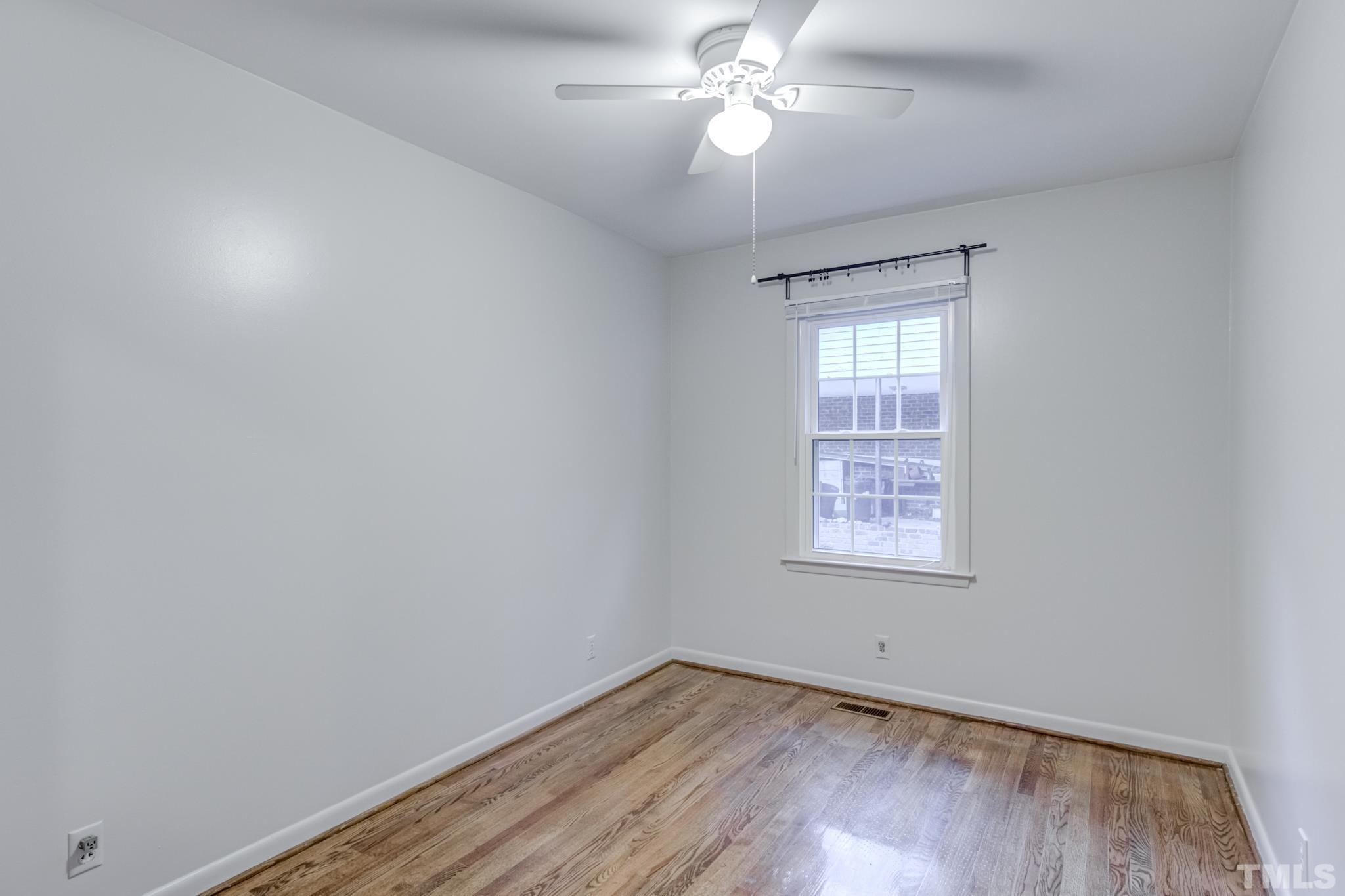 3213 Julian Drive Raleigh, NC 27604 - Photo 36 of 54 an empty room with wooden floor chandelier fan and windows