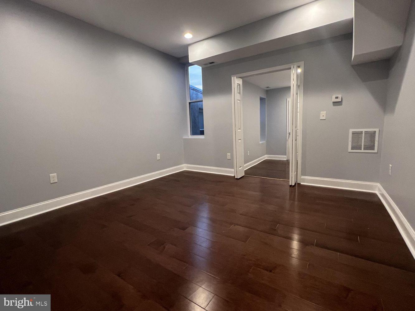 1607 East Biddle Street Baltimore, MD 21213 - Photo 11 of 23 an empty room with wooden floor and windows
