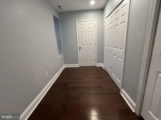a view of a hallway with wooden floor