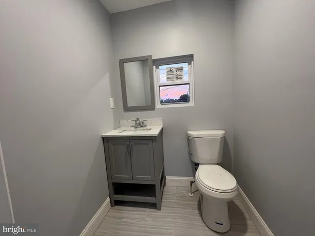 a bathroom with a toilet sink and mirror