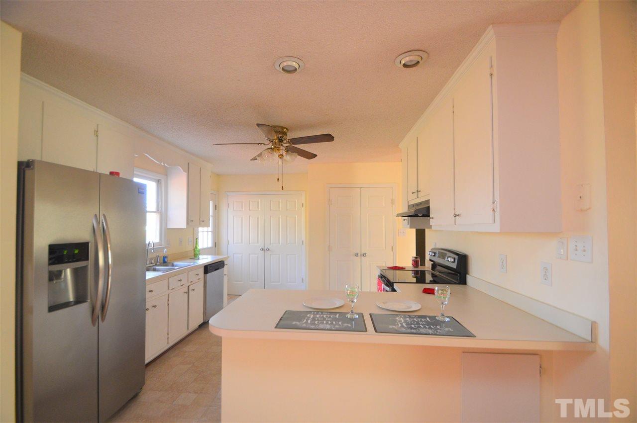 6801 Kiger Road Rougemont, NC 27572 - Photo 12 of 25 a kitchen with stainless steel appliances granite countertop a sink refrigerator and cabinets
