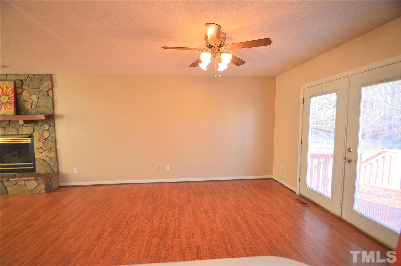 6801 Kiger Road Rougemont, NC 27572 - Photo 6 of 25 an empty room with wooden floor fan and windows