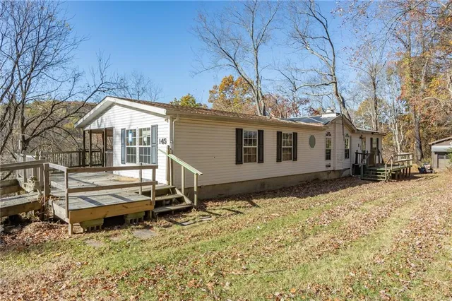 a backyard of a house with wooden fence and large trees