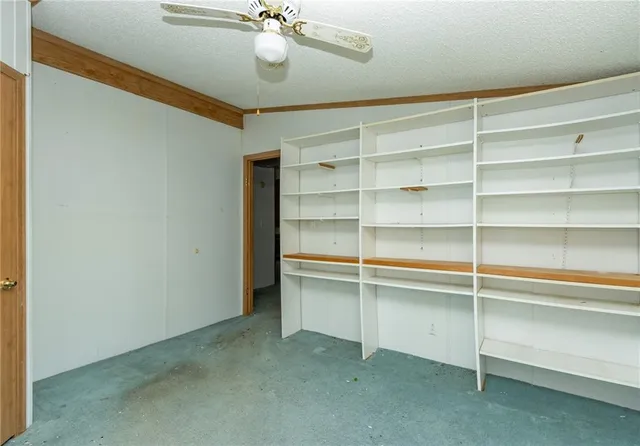 a view of an empty room with a cabinet and a window