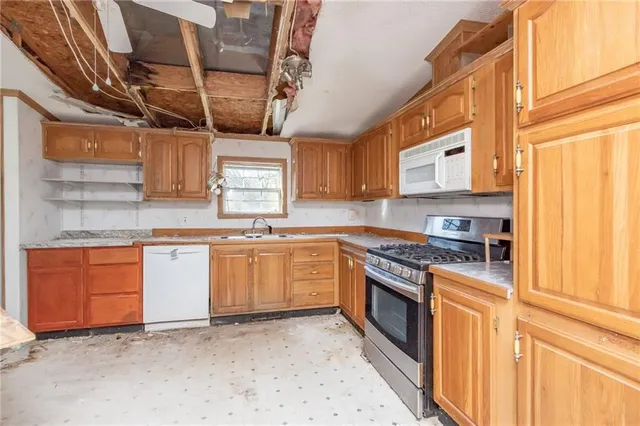 a kitchen with stainless steel appliances granite countertop a stove sink and cabinets