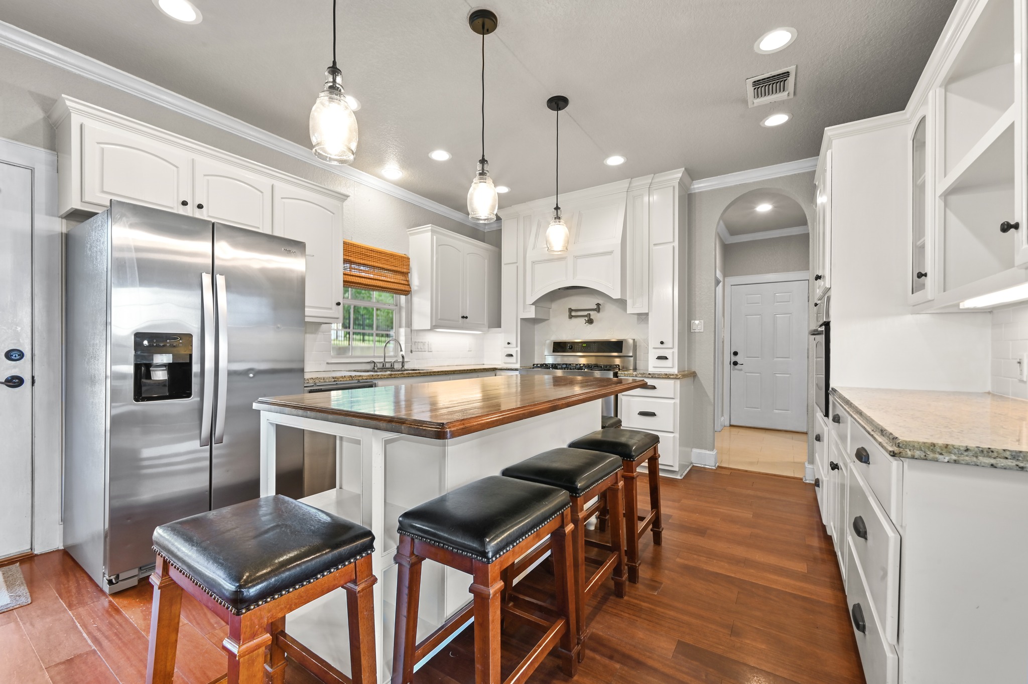 1175 Southern Way Luling, TX 78648 - Photo 21 of 40 Prepare culinary delights in this well-appointed kitchen, featuring a central island with bar seating and rich hardwood floors.