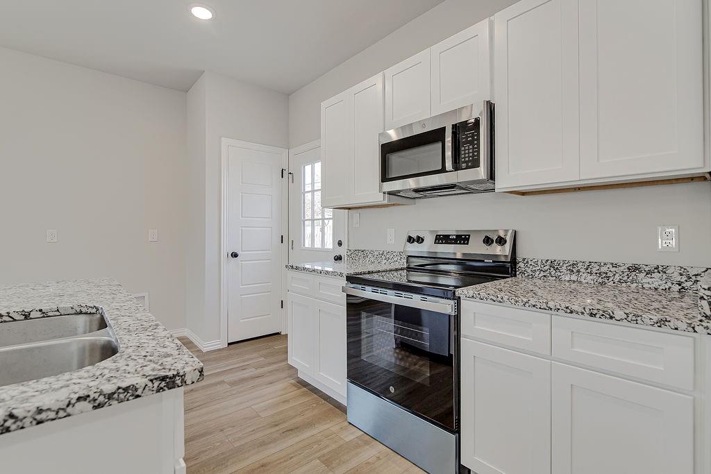 1520 Whippoorwill Way Azle, TX 76020 - Photo 12 of 25 a kitchen with stainless steel appliances granite countertop a stove microwave and sink