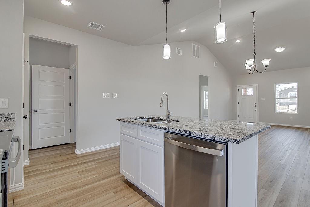 1520 Whippoorwill Way Azle, TX 76020 - Photo 13 of 25 a kitchen with stainless steel appliances granite countertop wooden floors and granite counter tops