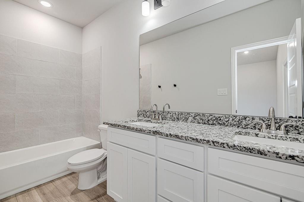 1520 Whippoorwill Way Azle, TX 76020 - Photo 17 of 25 a bathroom with a granite countertop sink a toilet and bathtub
