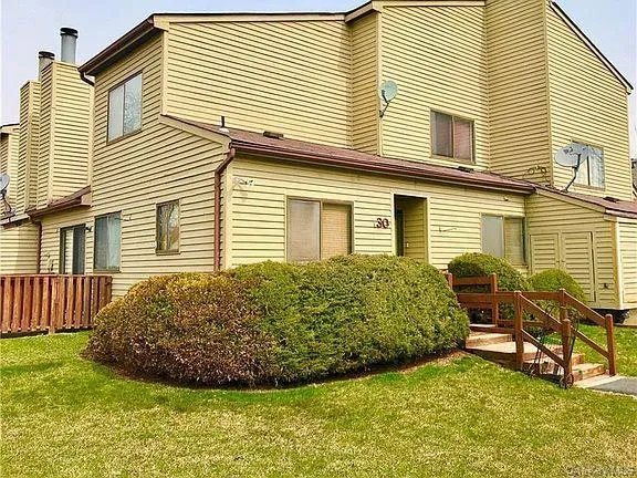 a view of a backyard with plants and wooden fence
