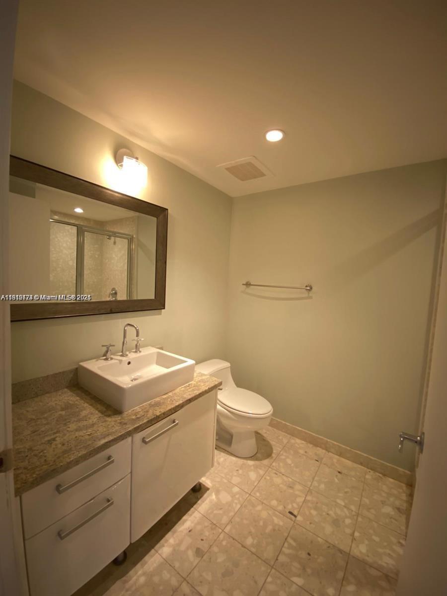 185 Southwest 7th Street, Unit 3306 Miami, FL 33130 - Photo 5 of 8 a bathroom with a toilet sink and mirror