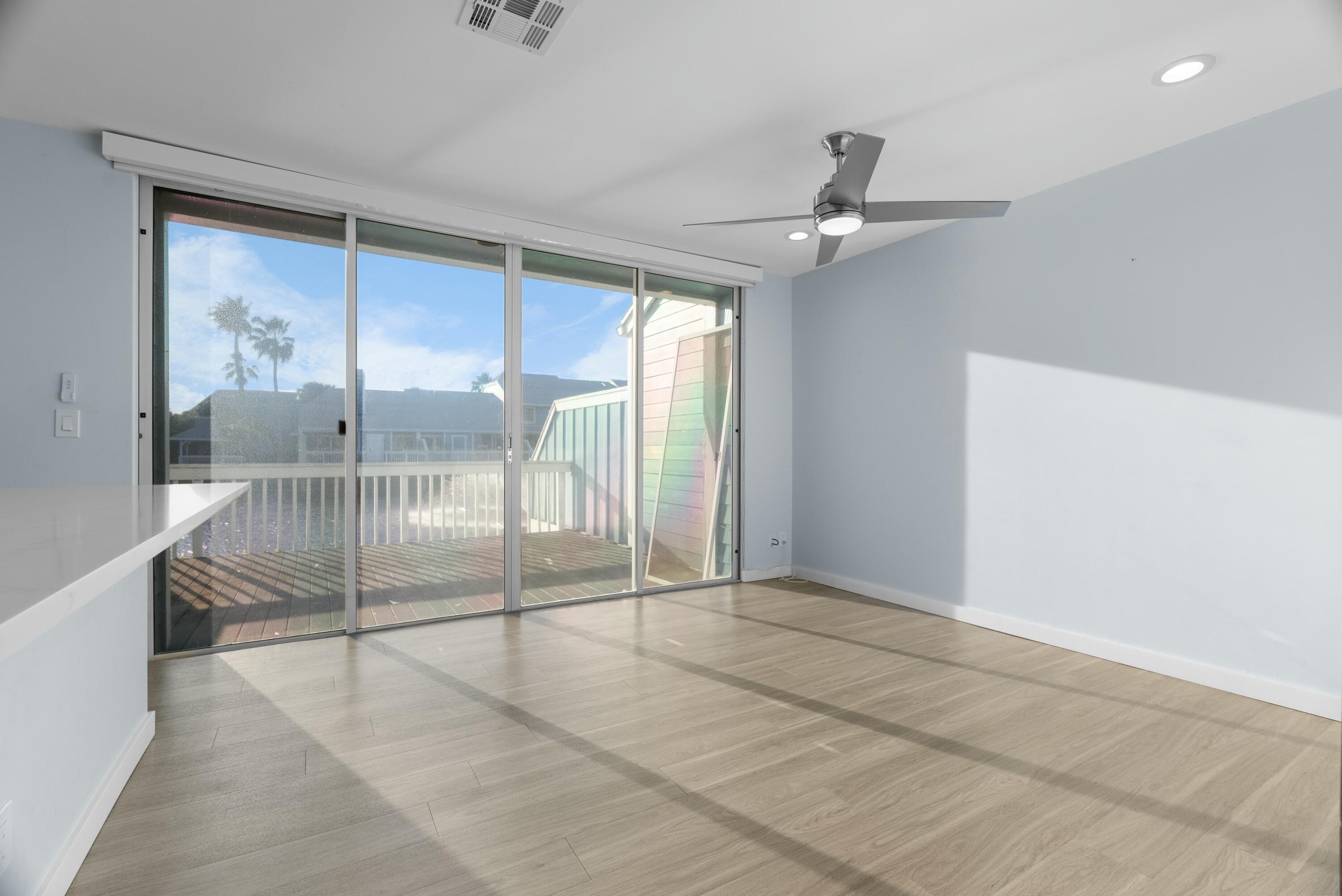 210 Ocean Dunes Circle Jupiter, FL 33477 - Photo 16 of 43 en empty room with sliding glass door and chandelier