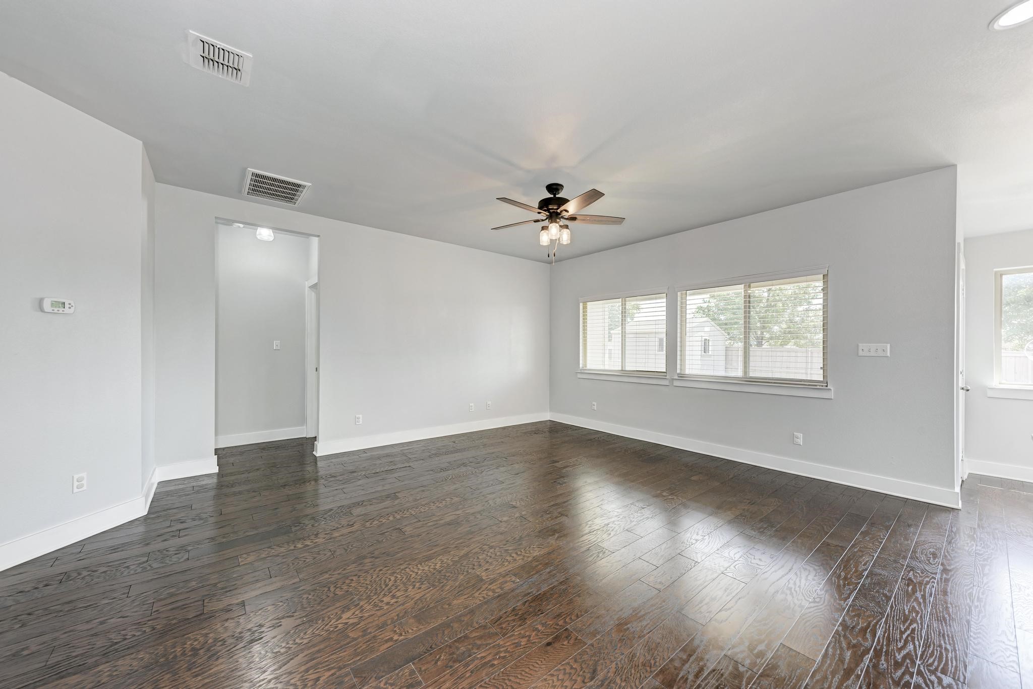 189 Tailwind Drive Kyle, TX 78640 - Photo 12 of 40 wooden floor in an empty room with a window