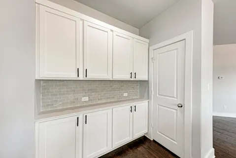 a kitchen with granite countertop white cabinets and sink