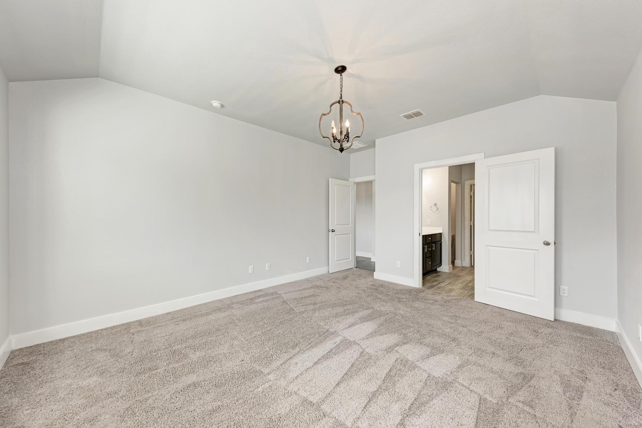 189 Tailwind Drive Kyle, TX 78640 - Photo 18 of 40 a view of an empty room with a chandelier