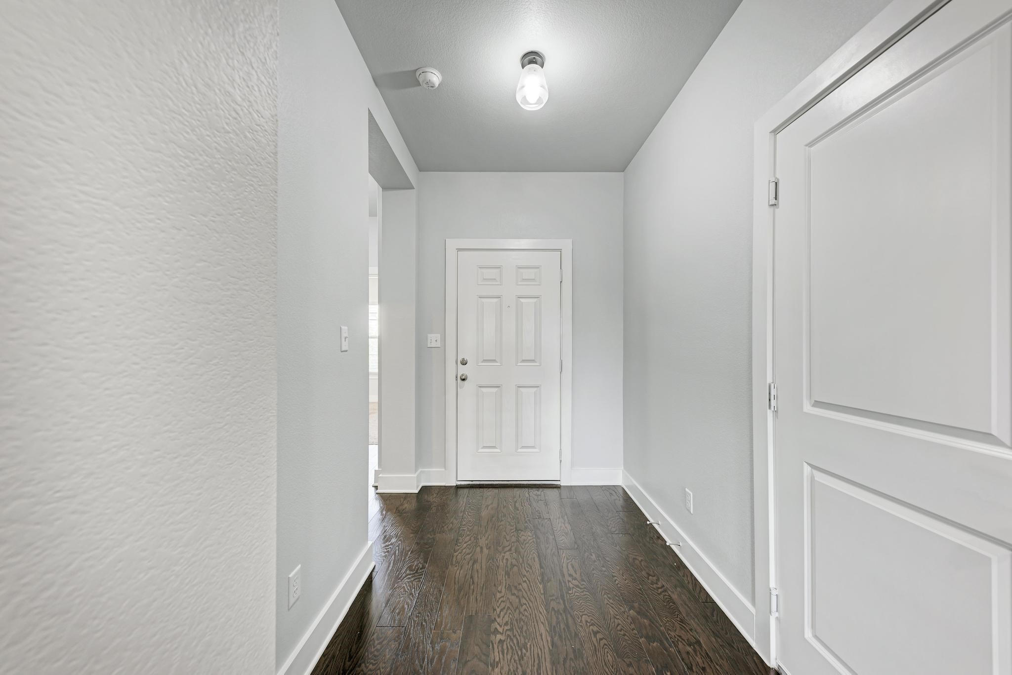 189 Tailwind Drive Kyle, TX 78640 - Photo 22 of 40 a view of a hallway with wooden floor