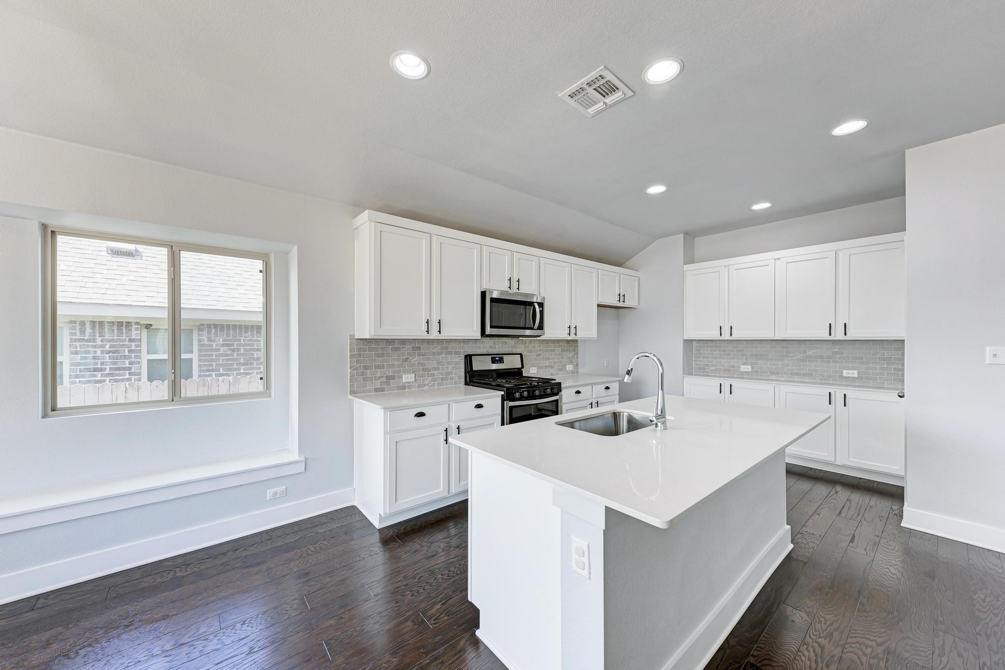 189 Tailwind Drive Kyle, TX 78640 - Photo 5 of 40 a kitchen with a sink a counter top space stainless steel appliances and cabinets