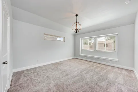 a view of an empty room with chandelier