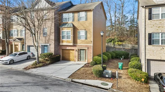 a view of a brick house with many windows next to a road