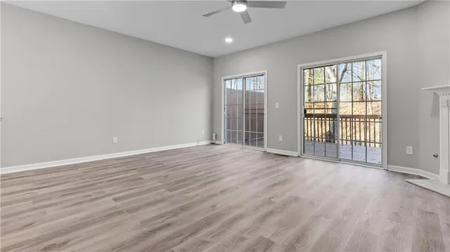 an empty room with wooden floor fireplace and cabinet
