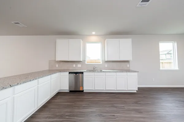 a kitchen with granite countertop white cabinets and white appliances