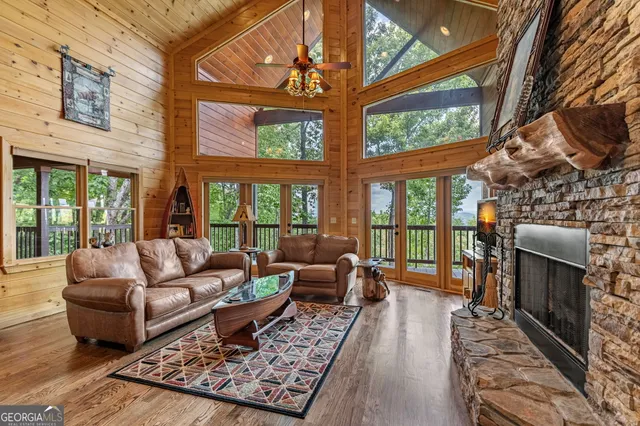 a living room with furniture a fireplace and a floor to ceiling window