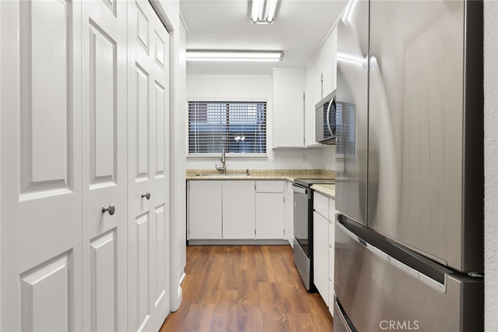 1420 Sherman Avenue, Unit 27 Chico, CA 95926 - Photo 11 of 29 a kitchen with cabinets oven and a wooden floor