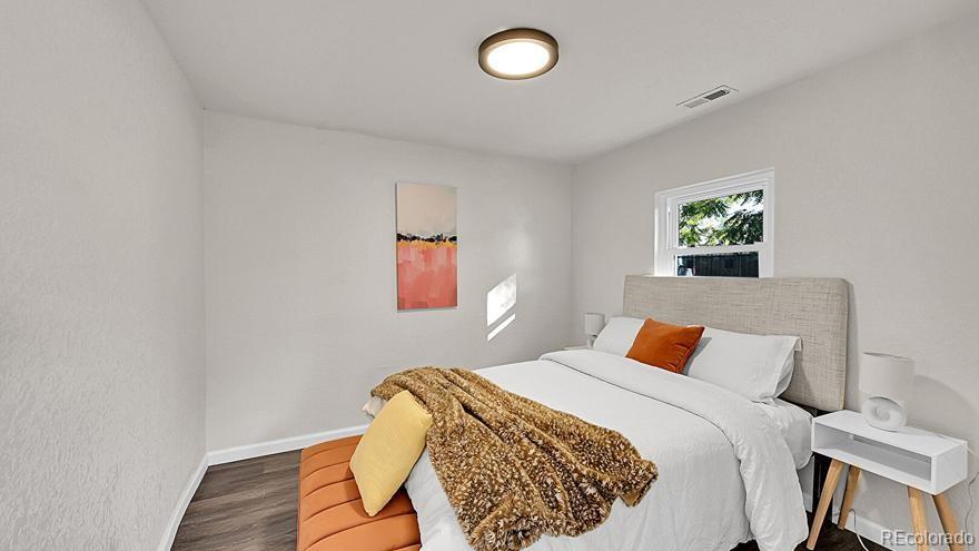 3984 Cook Street Denver, CO 80205 - Photo 7 of 34 a bedroom with a bed and a painting on the wall