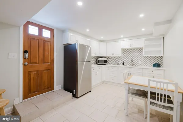 a view of kitchen with furniture and refrigerator