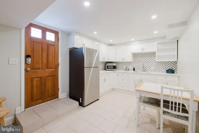a view of kitchen with furniture and refrigerator